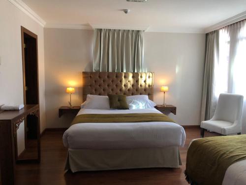 a hotel room with a large bed and a chair at Dakani Hotel Boutique NEW in Quito