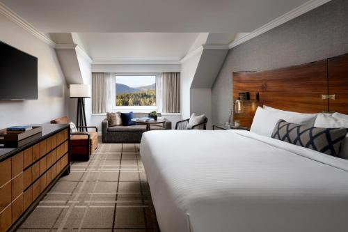 a hotel room with a large bed and a couch at Fairmont Chateau Whistler in Whistler