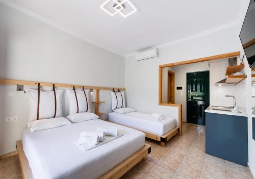 a hotel room with two beds and a kitchen at Nikolas Studios in Agios Nikitas