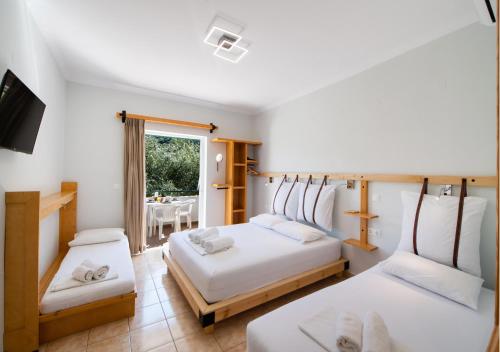 a bedroom with two beds and a dining room at Nikolas Studios in Agios Nikitas