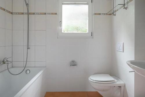 a white bathroom with a toilet and a sink at Camelot 1 in Bettmeralp