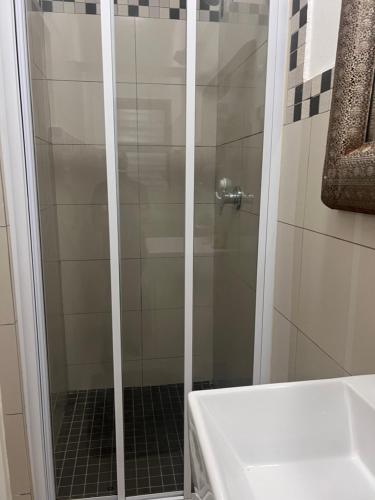 um chuveiro com uma porta de vidro na casa de banho em Umhlanga Ridge One Bedroom Self-Catering apartment em Durban