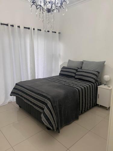 een slaapkamer met een bed en een kroonluchter bij Umhlanga Ridge One Bedroom Self-Catering apartment in Durban