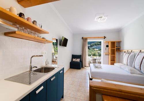 eine Küche mit einem Waschbecken und ein Bett in einem Zimmer in der Unterkunft Nikolas Studios in Agios Nikitas