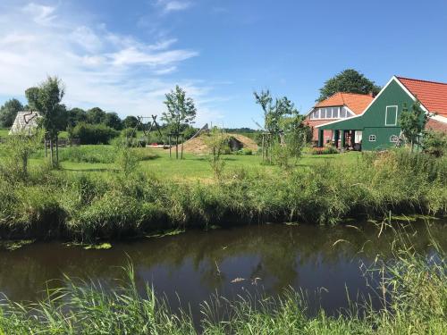 una casa con un estanque delante de ella en Hof am Siel, en Butjadingen