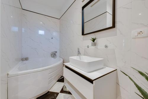 a white bathroom with a sink and a toilet at Luxury Seaview Apartment in Opatija