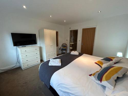 a bedroom with a large bed and a flat screen tv at Castlebar in Great Singleton