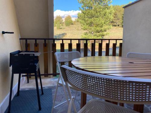 un tavolo e sedie su un balcone con vista su un campo di Monte Amaro Apartment con camino, terrazzo e giardino a Campo di Giove