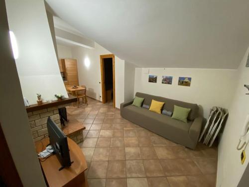 a living room with a couch and a television at Monte Amaro Apartment con camino, terrazzo e giardino in Campo di Giove