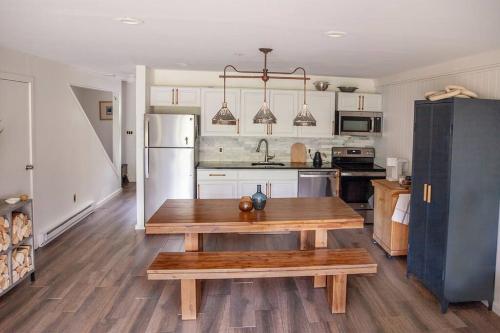 a kitchen with a wooden table and a refrigerator at 1 Mile to Hunter Mt! Cozy 3 Bedroom in Hunter