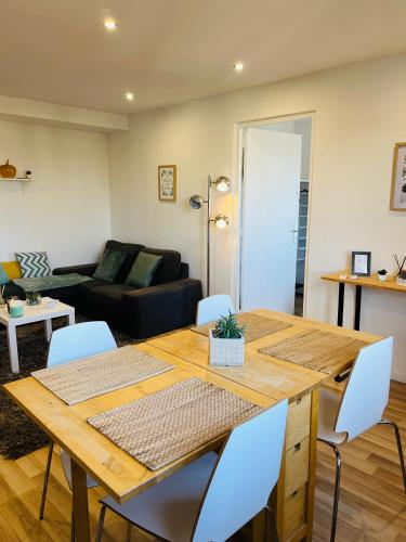 un salon avec une table et des chaises en bois dans l'établissement 3 chambres Situation idéale Aux portes de Lyon Tout confort, à Saint-Priest