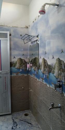 een badkamer met een douche en een muurschildering van de bergen bij HOTEL DEVDOOT in Rajgir