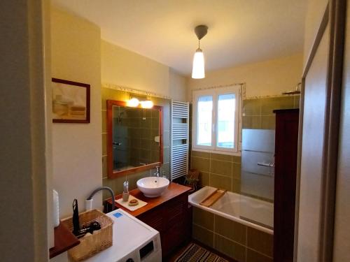 W łazience znajduje się umywalka i wanna. w obiekcie Grande maison familiale 300 m de la plage et du centre w mieście Sangatte