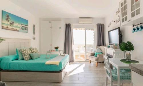 een slaapkamer met een bed, een tafel en een bureau bij EL ESTUDIO DE LA PLAYA BENALBEACH Holidays Deluxe in Benalmádena