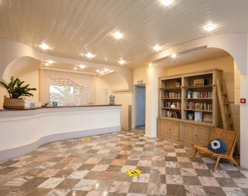 a room with a counter and a book shelf at Aurora Beach Hotel in Agios Ioannis Peristeron