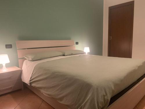 um quarto com uma grande cama branca e 2 candeeiros em 3T House 2 em Cremona