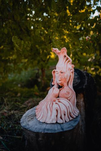a statue of a woman sitting on a stump at Village Jazz in Chimankend
