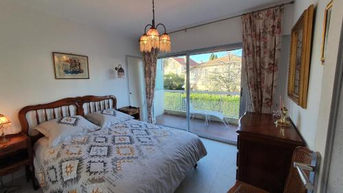 une chambre avec un lit et une grande fenêtre dans l'établissement Centre Cannes gd 2p terrasse parking 10mn palais plage, à Cannes