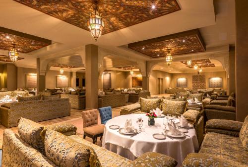 a restaurant with tables and couches and chairs at Berbère Palace in Ouarzazate
