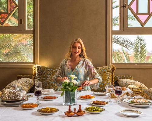 a woman sitting at a table with food at Berbère Palace in Ouarzazate