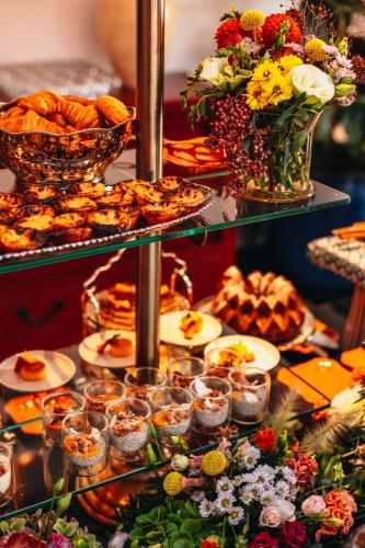 a buffet with many plates of food and flowers at Vinha Boutique Hotel - The Leading Hotels of the World in Vila Nova de Gaia