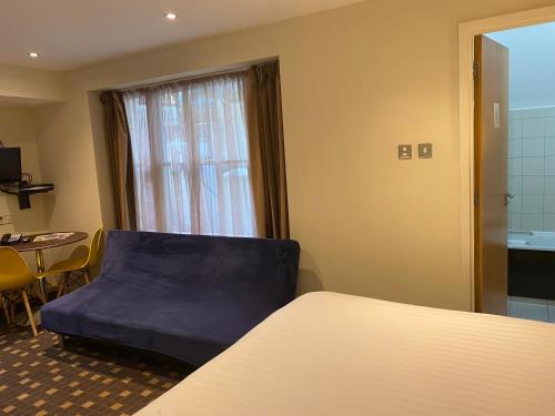 a room with a bed and a table and a window at Grand Plaza Serviced Apartments in London