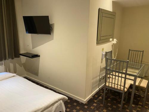 a room with a bed and a tv on the wall at Grand Plaza Serviced Apartments in London
