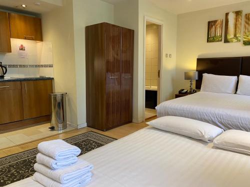 a hotel room with two beds and a kitchen at Grand Plaza Serviced Apartments in London
