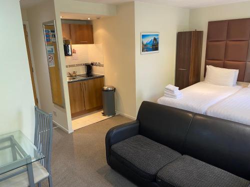 a bedroom with a bed and a couch and a kitchen at Grand Plaza Serviced Apartments in London