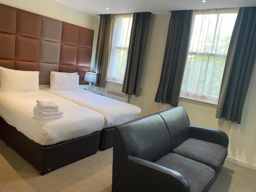 a bedroom with a bed and a chair at Grand Plaza Serviced Apartments in London