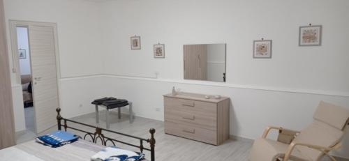 Schlafzimmer mit einem Bett, einer Kommode und einem Spiegel in der Unterkunft Casa vacanze Agrumeto in Latiano