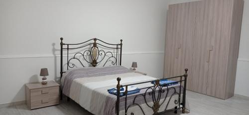 Schlafzimmer mit einem Bett und einem Holzschrank in der Unterkunft Casa vacanze Agrumeto in Latiano
