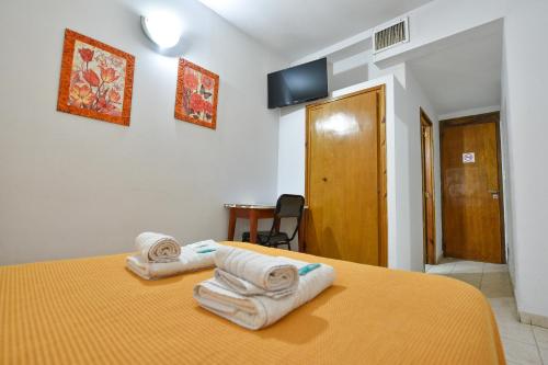 1 Schlafzimmer mit 2 Handtüchern auf einem Bett in der Unterkunft Hotel Simón in Trenque Lauquen