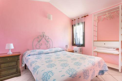 una camera da letto con pareti rosa, un letto e una finestra di SARDEGNA a Torre Dei Corsari