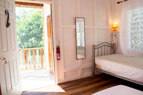 a bedroom with a bed and a door to a balcony at Horse Cottage triple deluxe #2 in Sarteneja