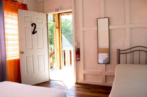 a bedroom with a bed and a open door at Horse Cottage triple deluxe #2 in Sarteneja