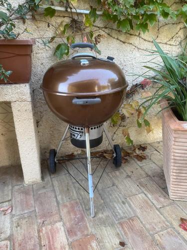 a barbecue grill on a stand in front of a wall at Casa felix in Loulé