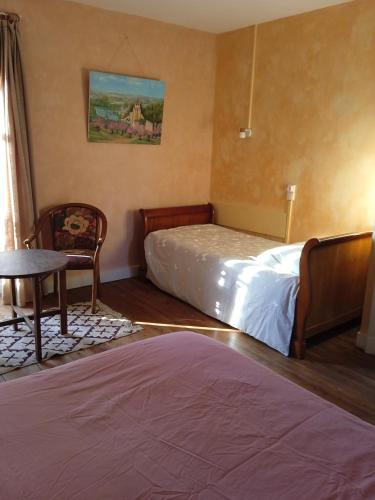 une chambre avec un lit, une table et une chaise dans l'établissement chambre chez l'habitant, axe A62, à 20 min d' ouest d'Agen, parking dans la rue gratuit, accès cuisine, convivial, à Port-Sainte-Marie