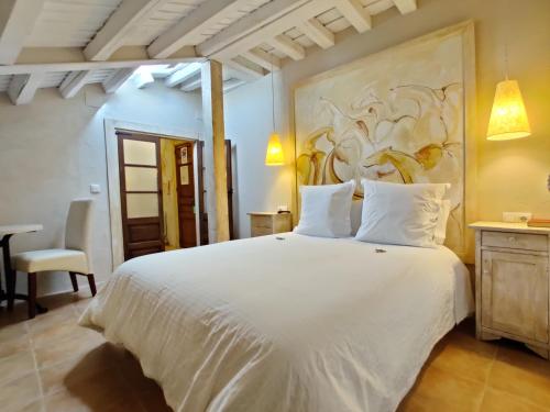 - une chambre avec un lit blanc orné d'une peinture murale dans l'établissement Posada Restaurante Casa de la Sal, à Candelario