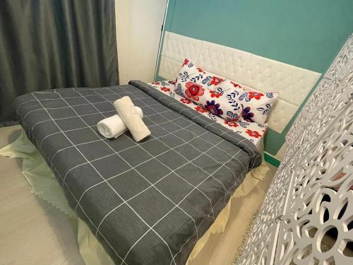 吉隆坡的住宿－Holiday Places by Homestay，一张带灰色毯子和枕头的床
