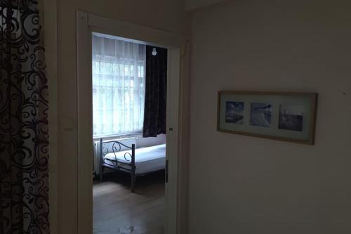 Cette chambre dispose d'une fenêtre avec un lit et une fenêtre. dans l'établissement 2+1 Aileye Uygun Haftalik ve Aylik, à Istanbul
