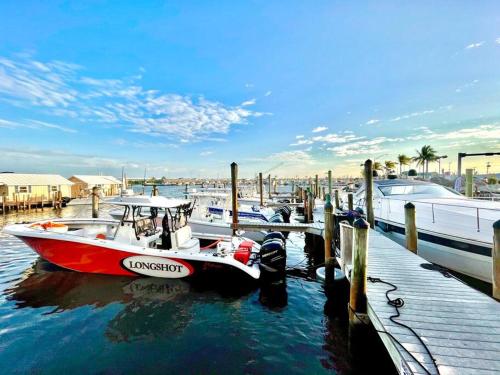 a red and white boat docked at a dock at Curacao - Large 2x2 Waterfront Condo Great View Pool & Dock in Key West