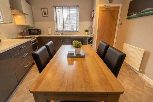 a kitchen with a wooden table and black chairs at Fishertown House in Nairn