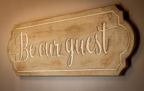 a sign that reads be our guest hanging on a wall at Fishertown House in Nairn