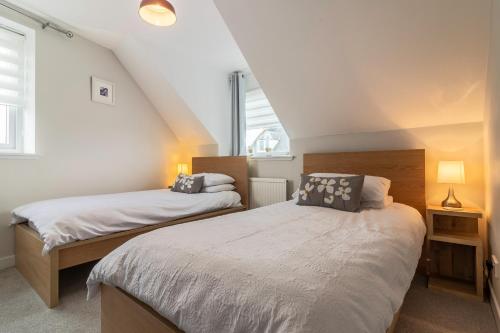 two beds in a room with a attic at Fishertown House in Nairn