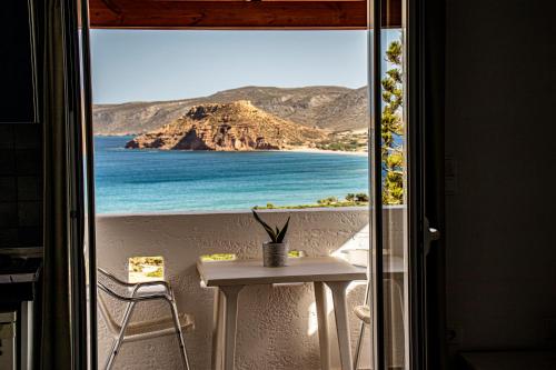 a view of the beach from a balcony with a table and chairs at Castri Village Hotel in Palekastron