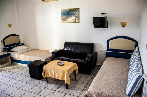 a room with two beds and a couch and a table at Castri Village Hotel in Palekastron