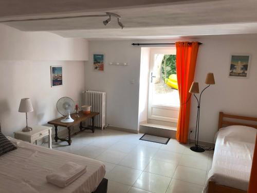 um quarto com uma cama e uma janela com uma cortina laranja em TOULON - Côte d'Azur - Magnifique maison avec piscine privée em Toulon