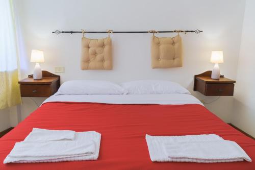 a bedroom with a red bed with two towels on it at Ostello-Albergo dagli Elfi in Barrea