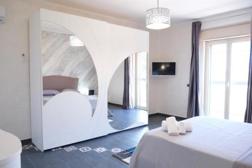 um quarto com uma cama branca com um arco em Sweet House Melania em Catânia
